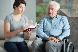 badante che legge ad un anziano