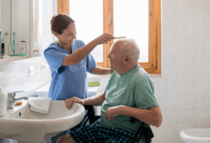 badante che accudisce un anziano pettinando i suoi capelli